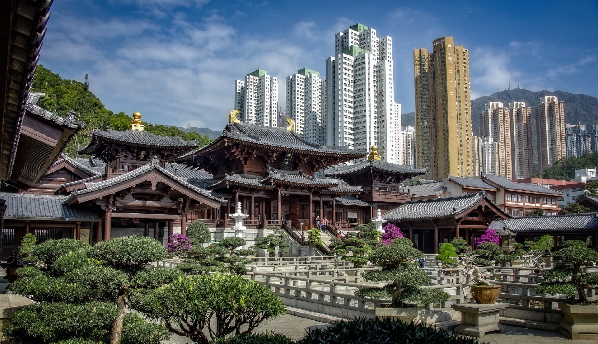 HD desktop wallpaper featuring traditional Hong Kong architecture in the foreground with modern high-rise buildings towering in the background under a clear blue sky.