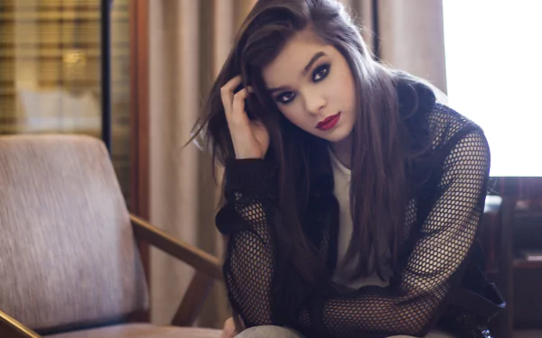 Hailee Steinfeld, American actress and singer, with brunette hair and bold lipstick, poses thoughtfully in a 4K Ultra HD desktop wallpaper.