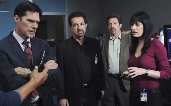 HD desktop wallpaper featuring characters from Criminal Minds discussing a case in their office.