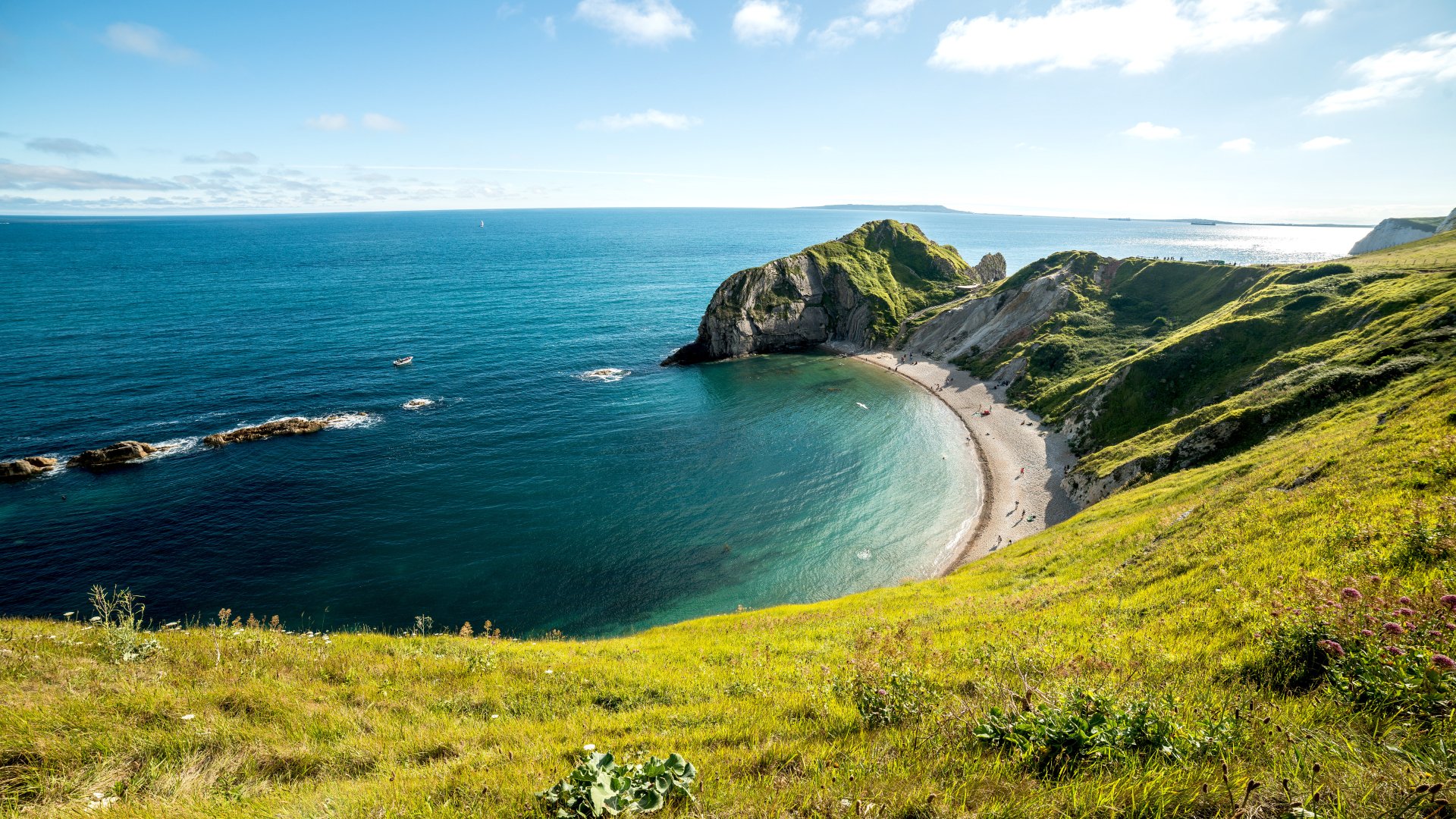 4K Ultra HD wallpaper showcasing Durdle Door coastline with cliffs, beach, sea, and a clear horizon under a bright sky.