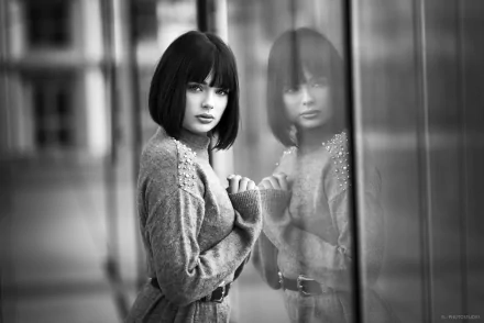 Black and white HD wallpaper of French model Marie Grippon with short hair, gazing thoughtfully at her reflection in a glass window.