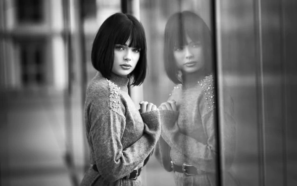 Black and white HD wallpaper of French model Marie Grippon with short hair, gazing thoughtfully at her reflection in a glass window.