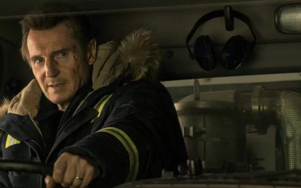 Liam Neeson in character, driving in a scene from Cold Pursuit, captured in a crisp HD desktop wallpaper.