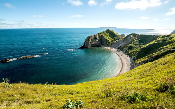 4K Ultra HD wallpaper showcasing Durdle Door coastline with cliffs, beach, sea, and a clear horizon under a bright sky.