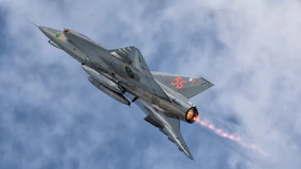 HD desktop wallpaper showing a Saab 35 Draken military jet fighter warplane climbing through clouds with afterburner glow, gray camouflage and Swedish roundels.