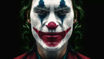 Close-up of Joaquin Phoenix as Joker with iconic clown makeup, captured in stunning 8K Ultra HD for a PC desktop wallpaper.