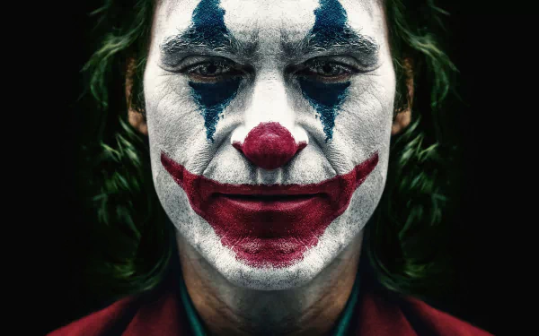 Close-up of Joaquin Phoenix as Joker with iconic clown makeup, captured in stunning 8K Ultra HD for a PC desktop wallpaper.