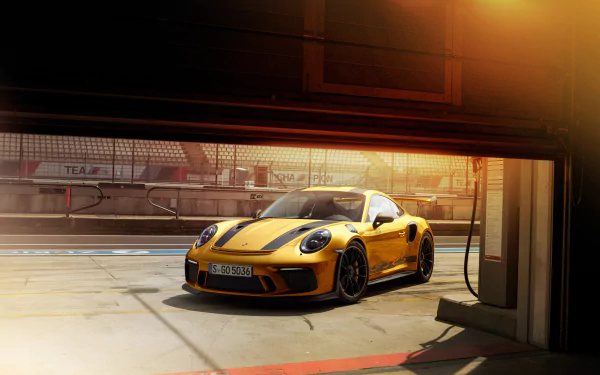 Yellow Porsche 911 GT3 parked in a garage with warm lighting, captured in stunning 4K Ultra HD as a PC desktop wallpaper and background.