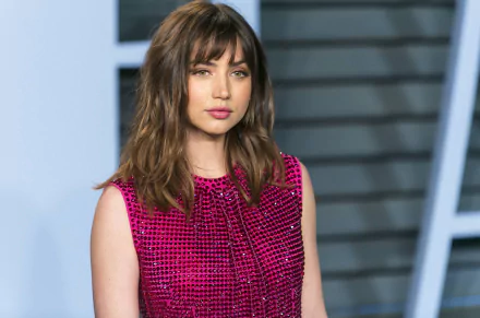 HD desktop wallpaper featuring Cuban actress Ana de Armas with green eyes and brunette hair, captured in a vibrant pink outfit.