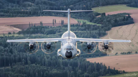 Front view of a military Airbus A400M transport aircraft flying over a rural landscape, captured in high definition as a PC desktop wallpaper.