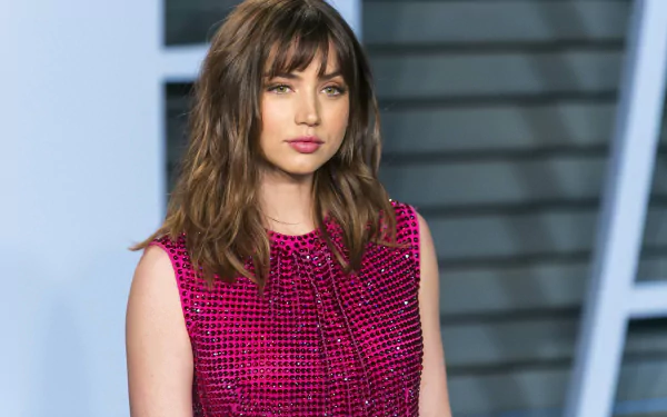 HD desktop wallpaper featuring Cuban actress Ana de Armas with green eyes and brunette hair, captured in a vibrant pink outfit.