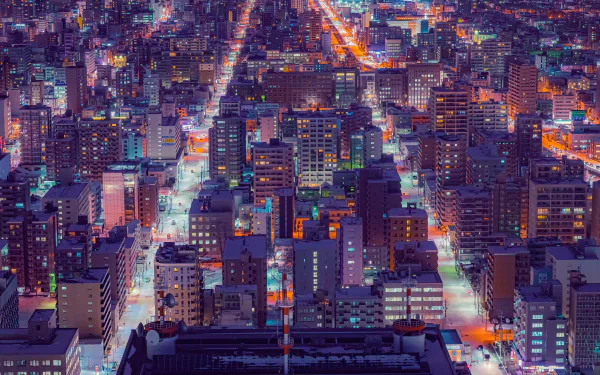 A vibrant 4K Ultra HD man-made cityscape of Sapporo at night, showcasing densely packed illuminated buildings and streets from an elevated perspective.