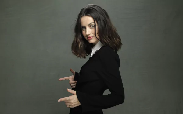 HD desktop wallpaper of Cuban actress Ana de Armas with brunette hair, posing confidently against a plain dark background.