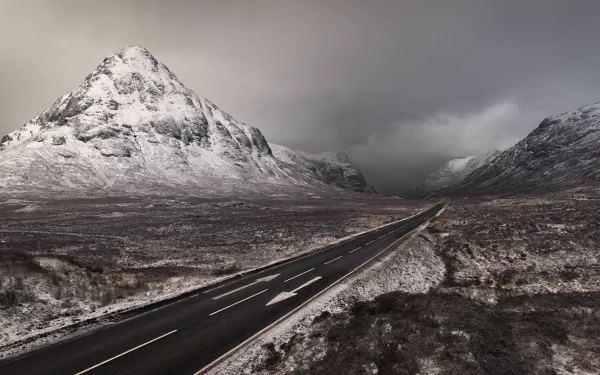 4K Ultra HD wallpaper showing a man-made road cutting through the rugged mountainous nature of Scotland under a cloudy sky.