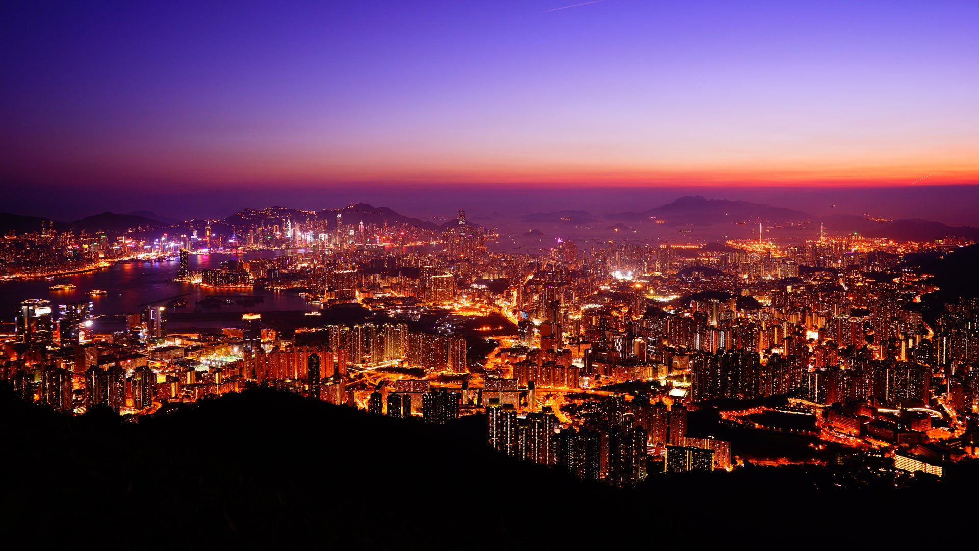 5K Ultra HD PC desktop wallpaper of Hong Kong cityscape at dusk, glowing skyscrapers and harbor lights stretching across the skyline.