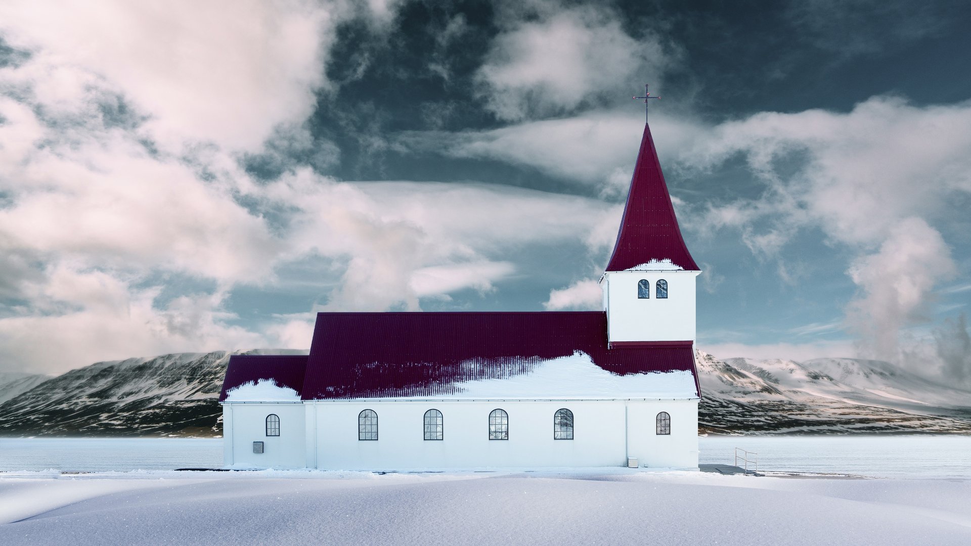 4K Ultra HD desktop wallpaper of a snow-covered church under a moody sky, blending religious architecture with serene winter landscape.