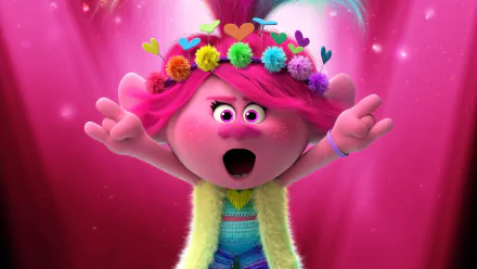 Poppy from Trolls World Tour singing with arms wide, pink hair and flower crown, colorful outfit against a glowing pink backdrop — 4K Ultra HD PC desktop wallpaper/background.