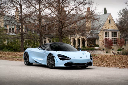 Light blue McLaren 720S supercar parked before a stone mansion with bare trees and fallen leaves — HD PC desktop wallpaper/background featuring a McLaren car vehicle.