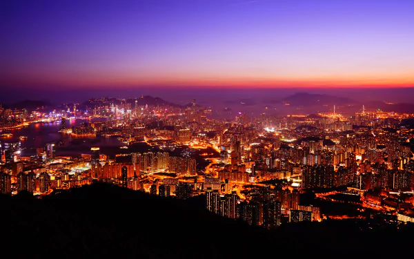 5K Ultra HD PC desktop wallpaper of Hong Kong cityscape at dusk, glowing skyscrapers and harbor lights stretching across the skyline.