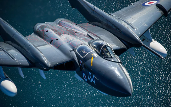 HD desktop wallpaper featuring a military de Havilland Sea Vixen jet fighter warplane in flight over water.