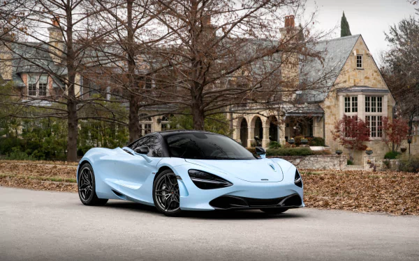 Light blue McLaren 720S supercar parked before a stone mansion with bare trees and fallen leaves — HD PC desktop wallpaper/background featuring a McLaren car vehicle.