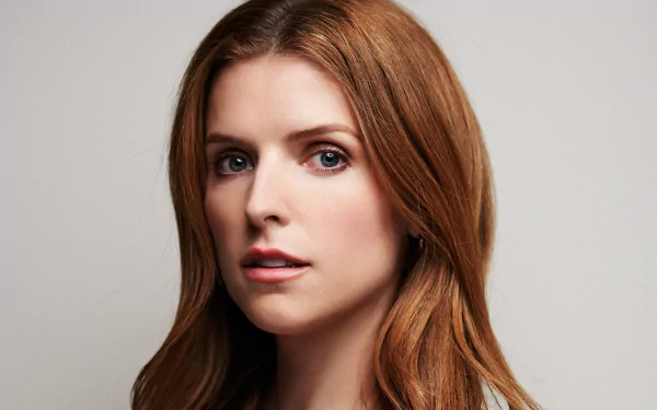 Close-up portrait of American actress Anna Kendrick with red hair and blue eyes, shown against a neutral background for an HD desktop wallpaper.