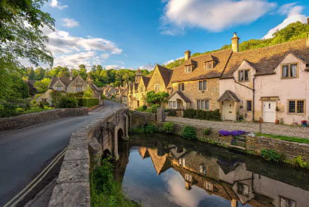 4K UHD desktop wallpaper of a Cotswolds village in Wiltshire, England: man-made stone bridge spanning a river, honey-coloured cottages and their reflections under a blue sky.