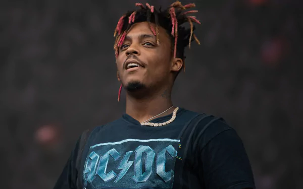 A vibrant HD desktop wallpaper featuring Juice Wrld performing, showcasing his energetic presence and unique style in the world of music.