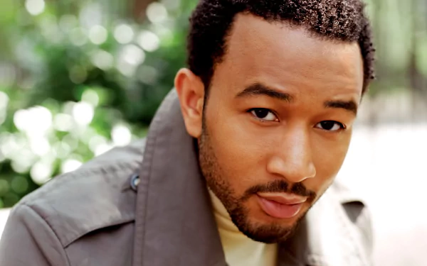 HD desktop wallpaper featuring a close-up of a man with a thoughtful expression, tagged for a musician, against a blurred green background.