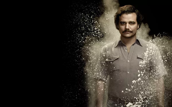 HD desktop wallpaper of the TV show Narcos features Pablo Escobar standing against a dark background with white powder effects around him.