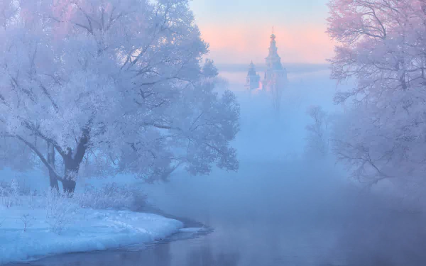 Winter scene of a foggy river flowing past a snow-covered monastery and church, surrounded by frosted trees in a serene religious landscape.