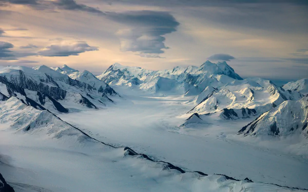 Snow-capped peak towering in serene natural surroundings, a breathtaking HD desktop wallpaper of majestic mountain scenery.