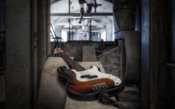 4K Ultra HD PC desktop wallpaper: sunburst electric guitar, an instrument of music, resting on a concrete ledge in a moody industrial interior.