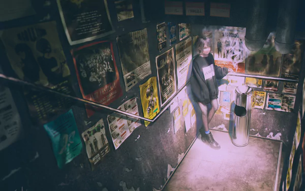 Anime-style HD desktop wallpaper depicting a person standing by stairs, surrounded by posters, emitting cigarette smoke in a dimly lit urban setting.