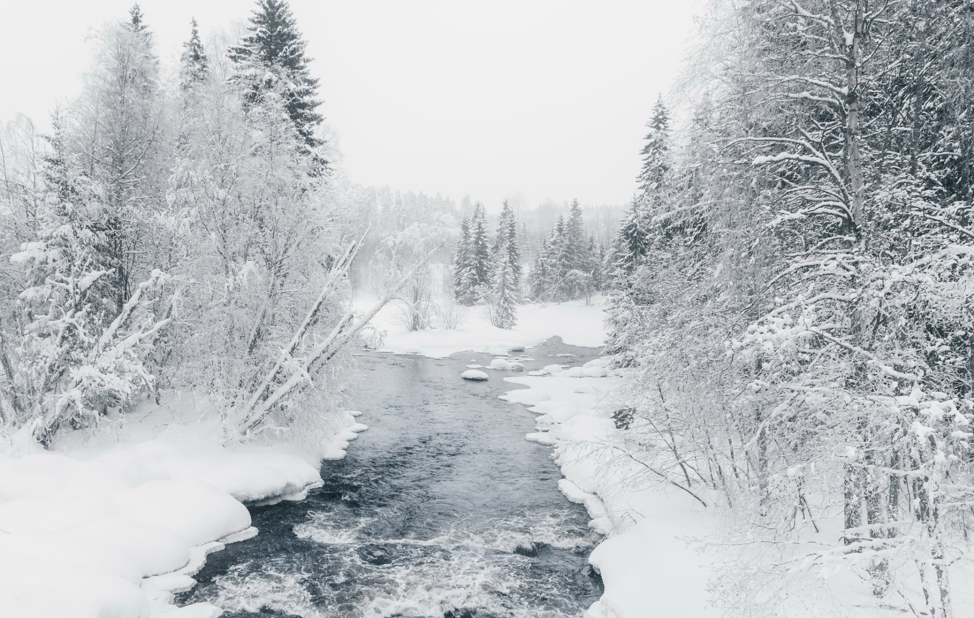 HD desktop wallpaper of a winter river flowing through a snow-covered forest in nature, showcasing serene and crisp snowy landscapes.