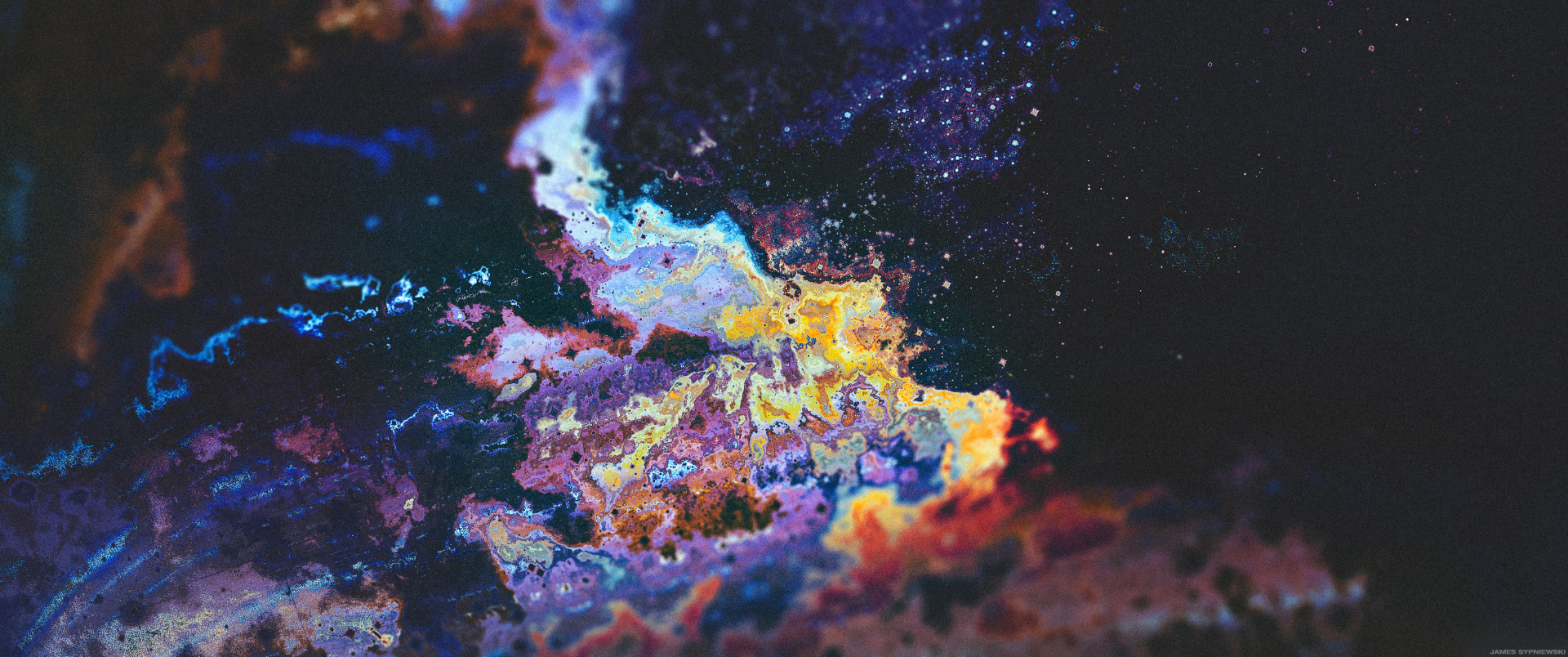 Abstract colorful nebula-like pattern of vivid blues, purples and yellows with starry flecks — 2K Quad HD PC desktop wallpaper and background.