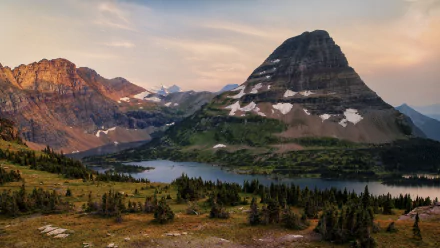 4K Ultra HD PC desktop wallpaper and background: panoramic mountain and river landscape with spruce forests in the foreground and snow-dusted alpine peaks beneath a pastel sky.