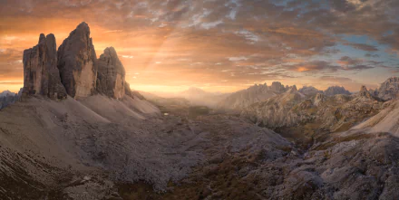 Sunrise over the rugged peaks of Tre Cime di Lavaredo in the Dolomites, captured in stunning 4K Ultra HD with a dramatic sky and expansive rocky landscape.