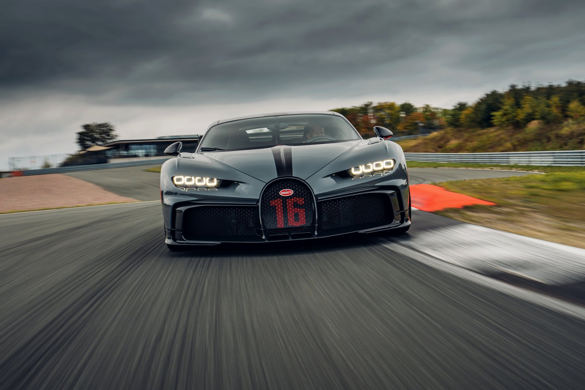 Front view of a black Bugatti Chiron Pur Sport supercar speeding on a racetrack, captured in 4K Ultra HD for PC desktop wallpaper and background.