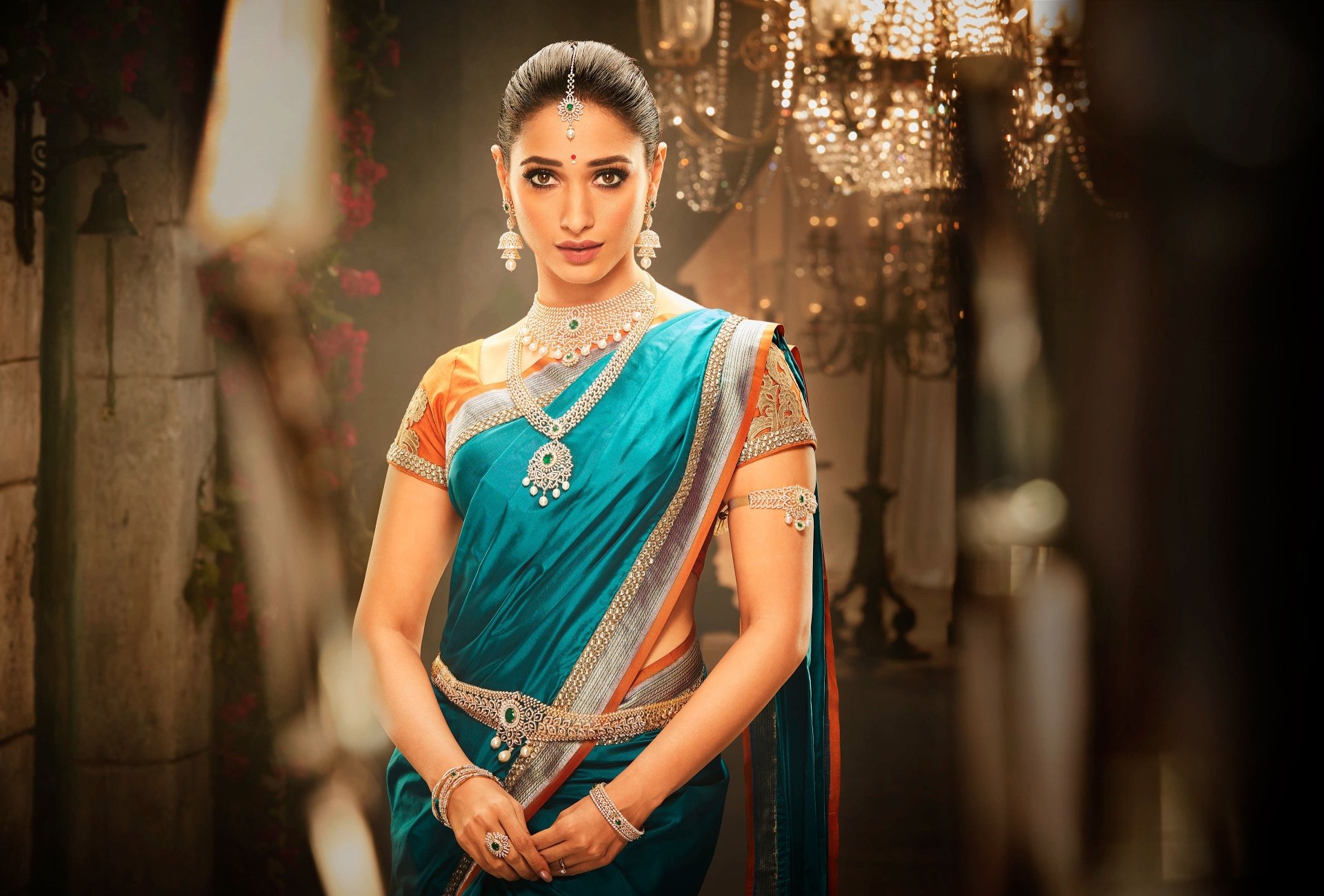 A 4K Ultra HD PC wallpaper featuring celebrity Tamannaah Bhatia in traditional attire, adorned with jewelry, set against a softly lit, elegant background.