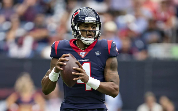 HD desktop wallpaper featuring a quarterback ready to throw a football on the field.