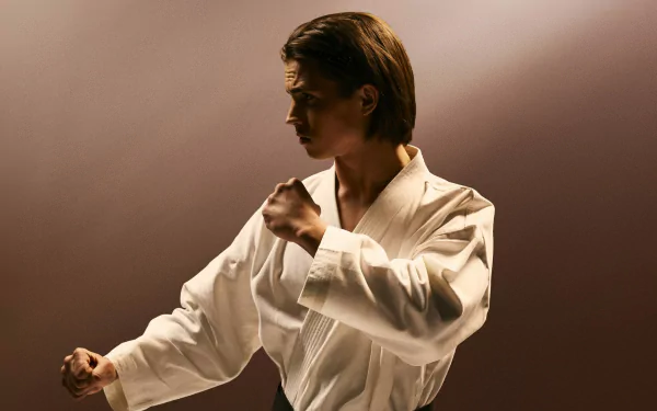 HD desktop wallpaper featuring Tanner Buchanan as Robby Keene from Cobra Kai in a martial arts stance.