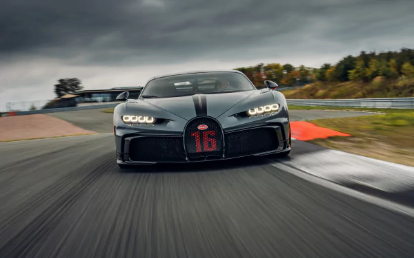 Front view of a black Bugatti Chiron Pur Sport supercar speeding on a racetrack, captured in 4K Ultra HD for PC desktop wallpaper and background.