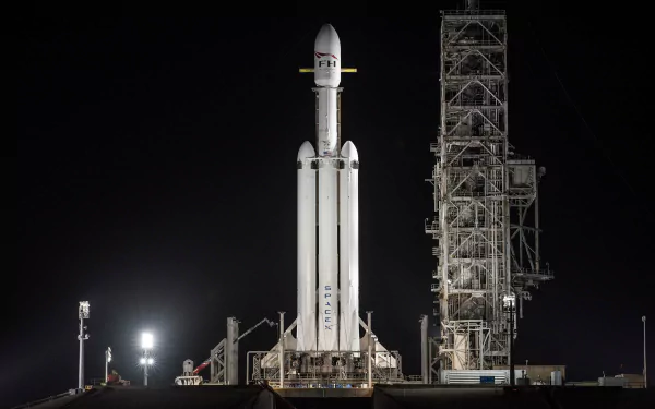 HD desktop wallpaper of SpaceX Falcon Heavy rocket at launch pad during nighttime.
