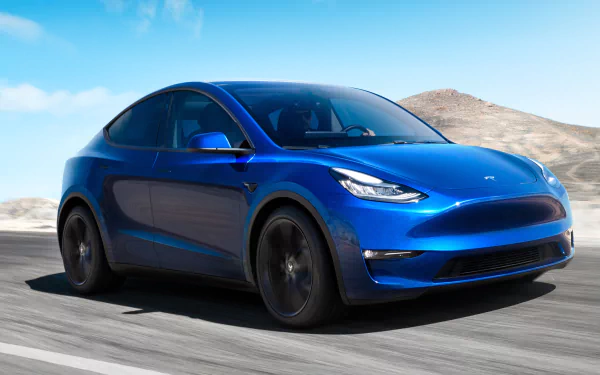 A blue Tesla Model Y electric car in motion, suitable as a high-definition desktop wallpaper or background.