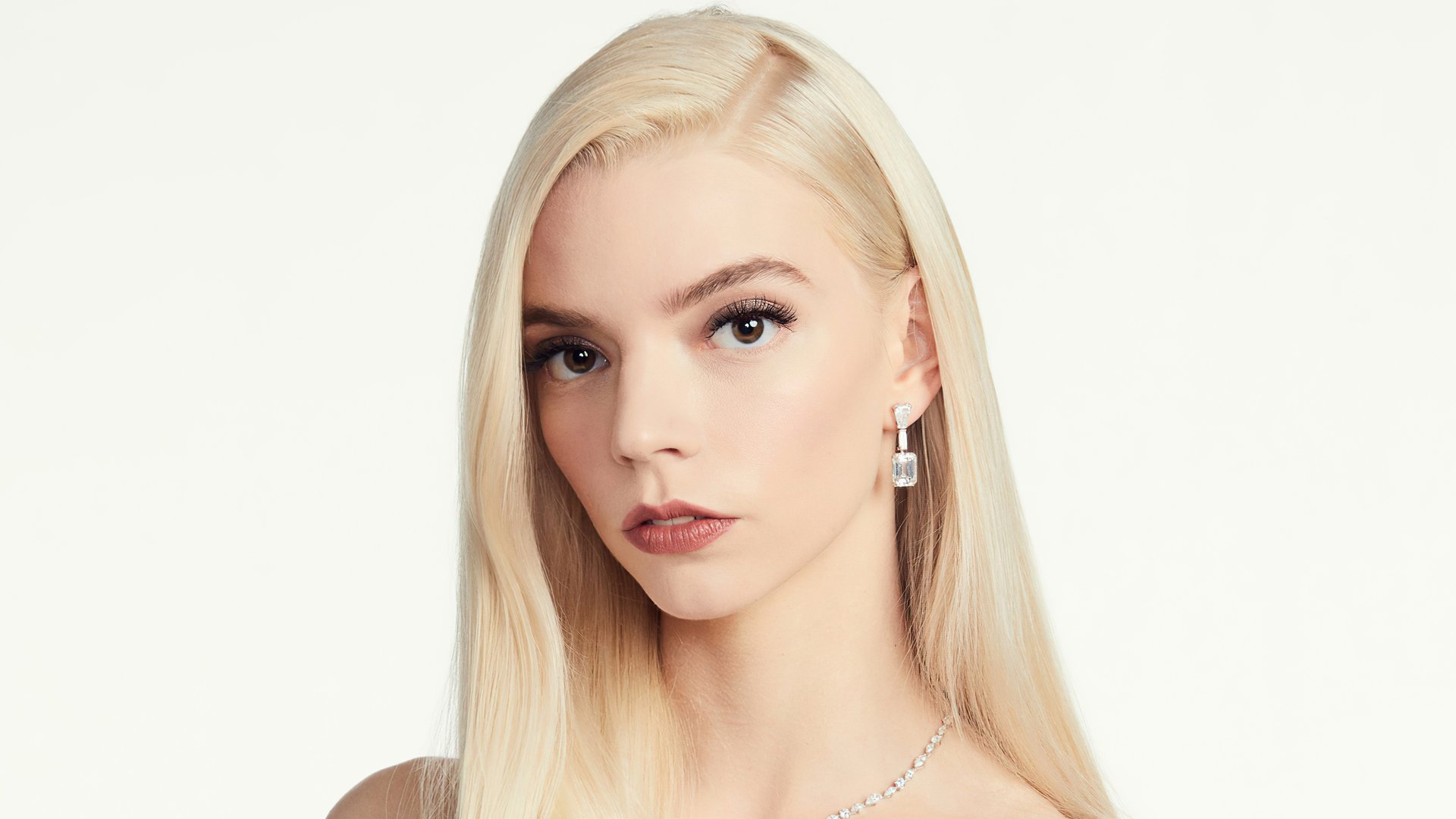 Close-up 4K Ultra HD image of American actress Anya Taylor-Joy with blonde hair and a neutral expression against a plain background.