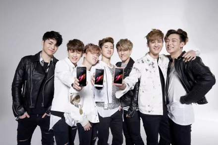 HD wallpaper of iKON, a group of smiling young men posing with smartphones, for desktop background.