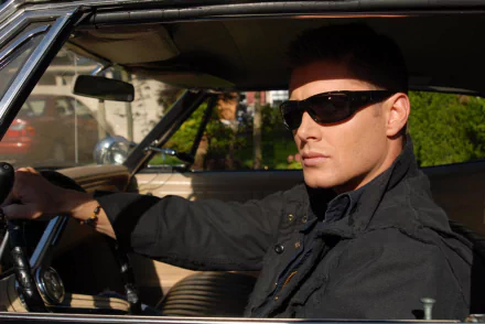 Dean Winchester, played by Jensen Ackles in Supernatural, sits confidently in a car wearing sunglasses; HD PC desktop wallpaper and background.