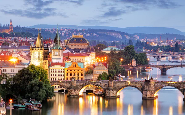 HD PC desktop wallpaper and background: dusk skyline of Prague, Czech Republic with the illuminated Charles Bridge and historic man-made architecture reflected in the Vltava River.