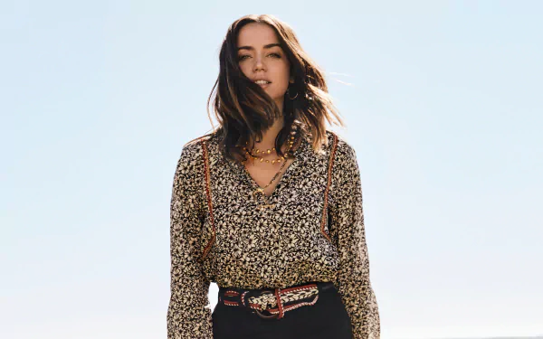 Portrait of Cuban actress Ana de Armas with green eyes and brunette hair, captured in 4K Ultra HD quality against a clear sky background.